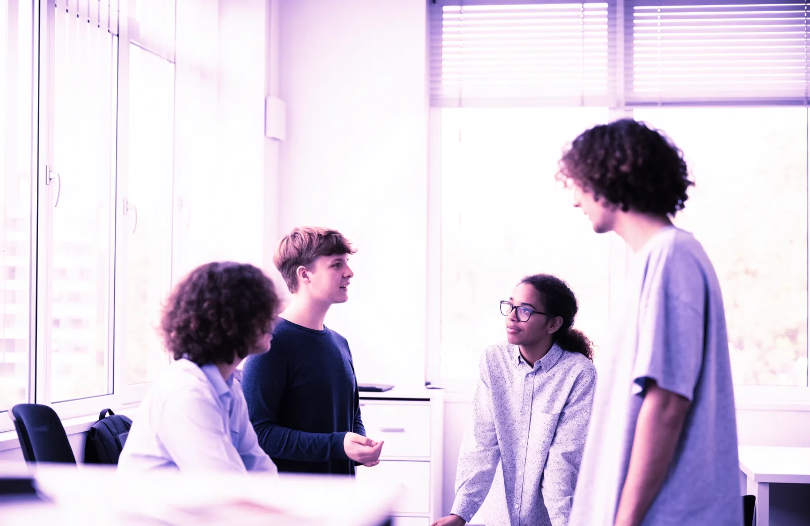 Vierköpfiges Team im Gespräch in einem hellen Büro